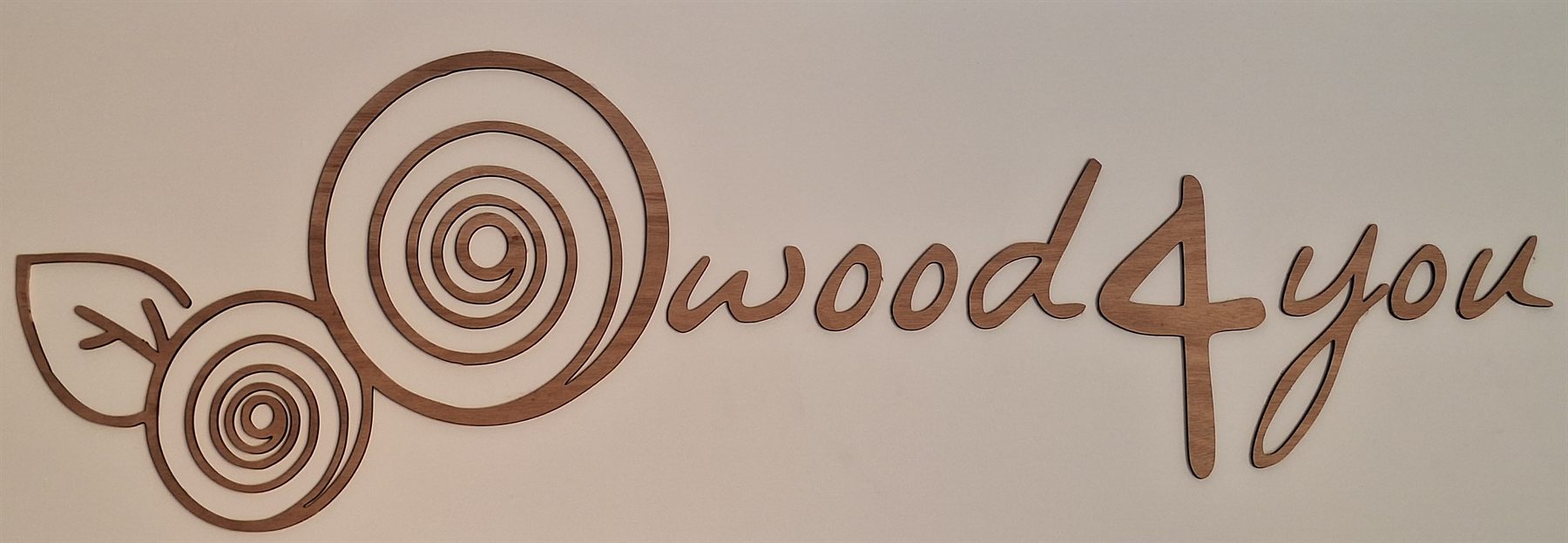 Il logo WOOD4YOU tagliato al laser nel legno e applicato sulla parete